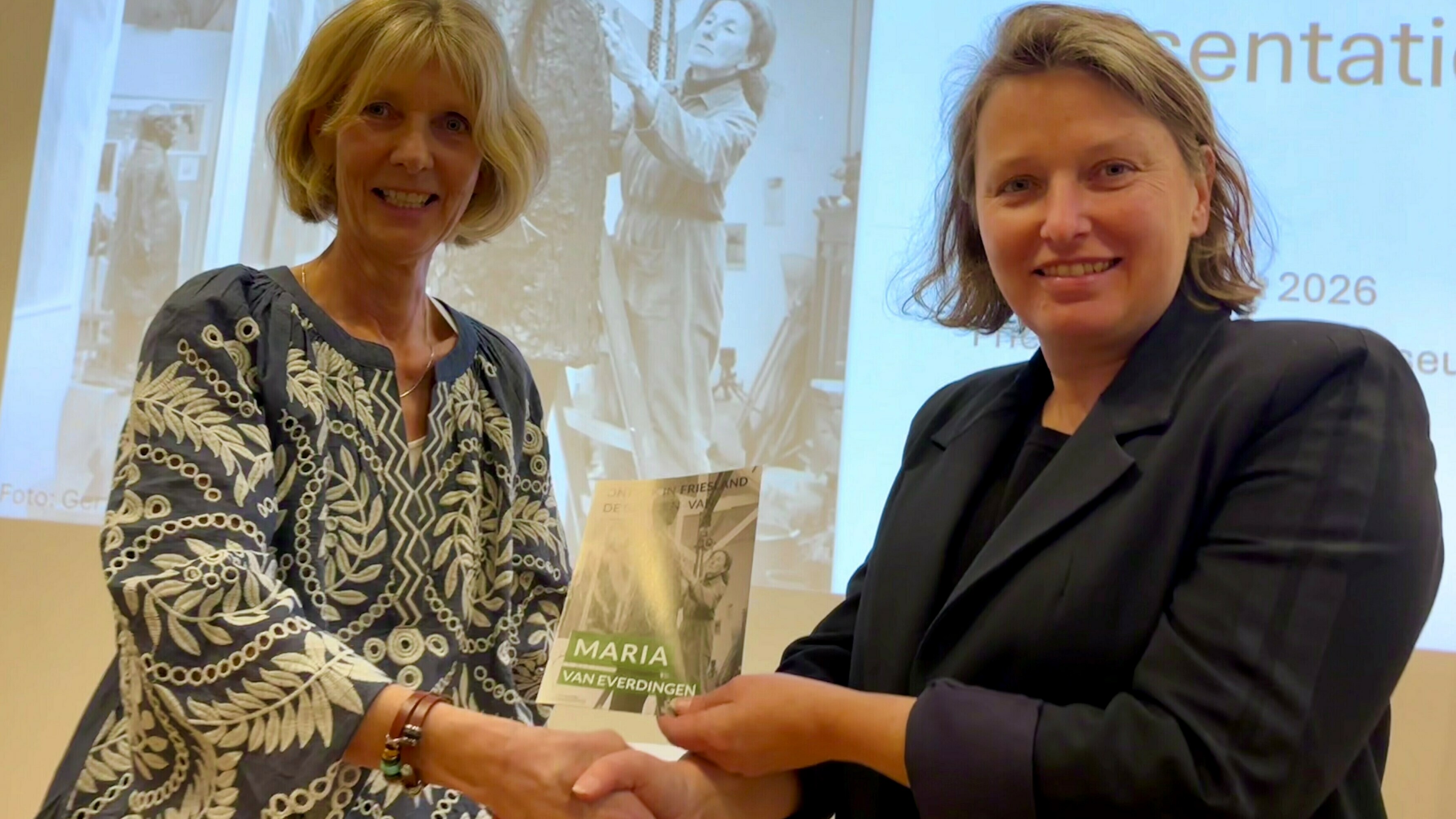 Tiny Boonstra oerlanget de earste folder oan Esther Postma, direkteur Fries Scheepvaart Museum