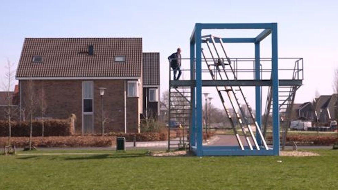 Hemelsblauw tekent de stalen kubusvormige constructie tegen de lucht af. Aan beide kanten zit ook een trap. En het kunstwerk staat aan de rand van een speelterrein in Elst.