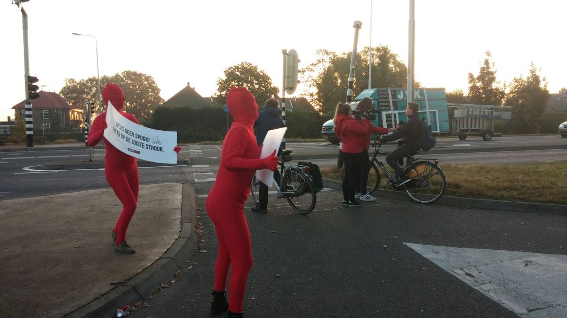 Een ludieke actie dinsdagmorgen langs de N324 bij Nederasselt. Fietsers die daar tegen het verkeer in rijden of rood licht negeren, worden aangesproken door rode mannetjes.