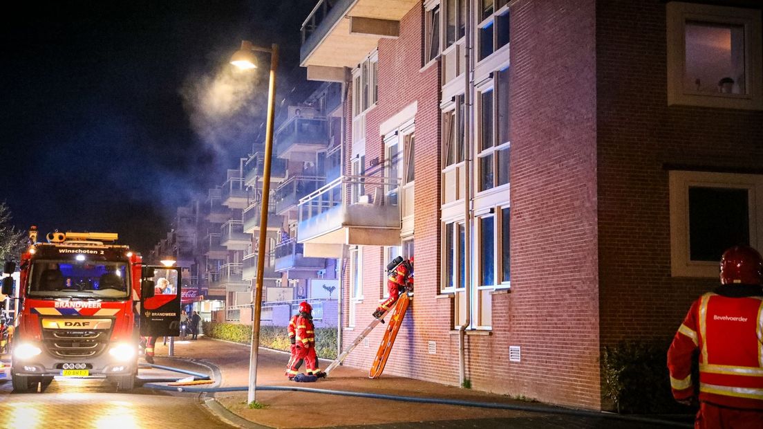 De brandweer gaat het brandende pand binnen