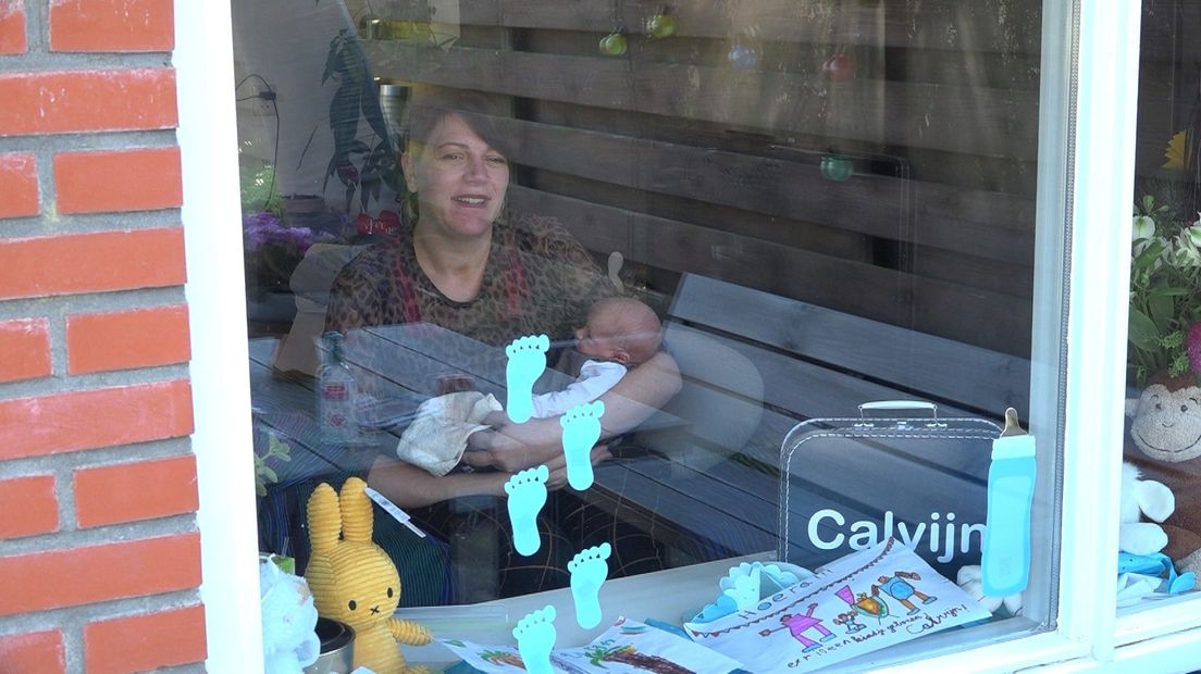 Moeder Saskia laat haar pasgeboren zoon Calvijn zien aan de 'raamvisite'