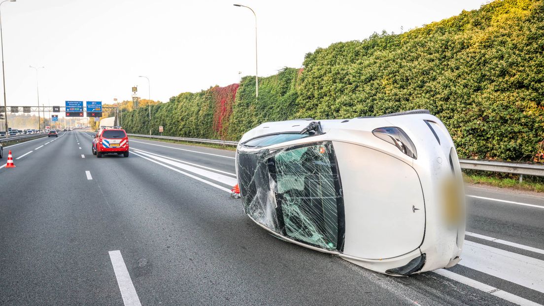 Een witte Tesla belandde meters verderop op zijn kant