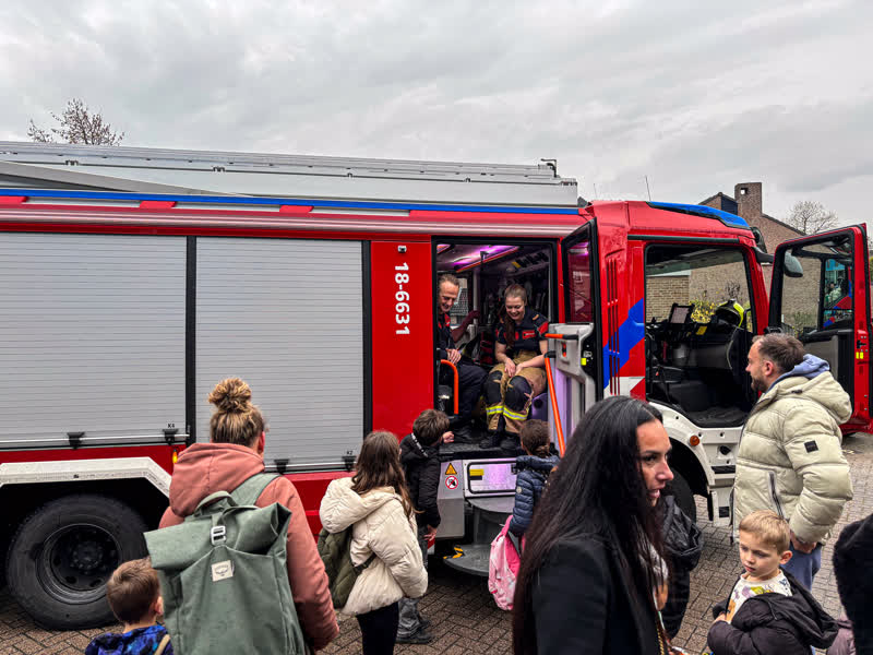 Kinderen vermaken zich bij een brandweerauto.