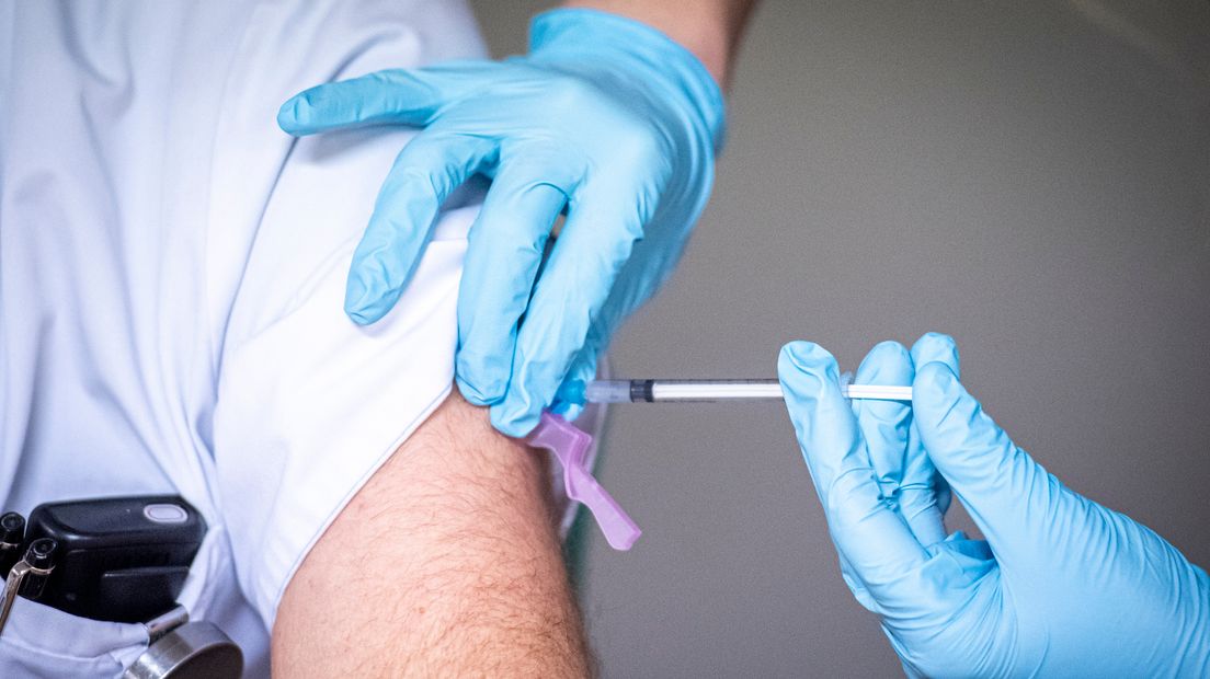 Een zorgmedewerker krijgt een vaccinatie