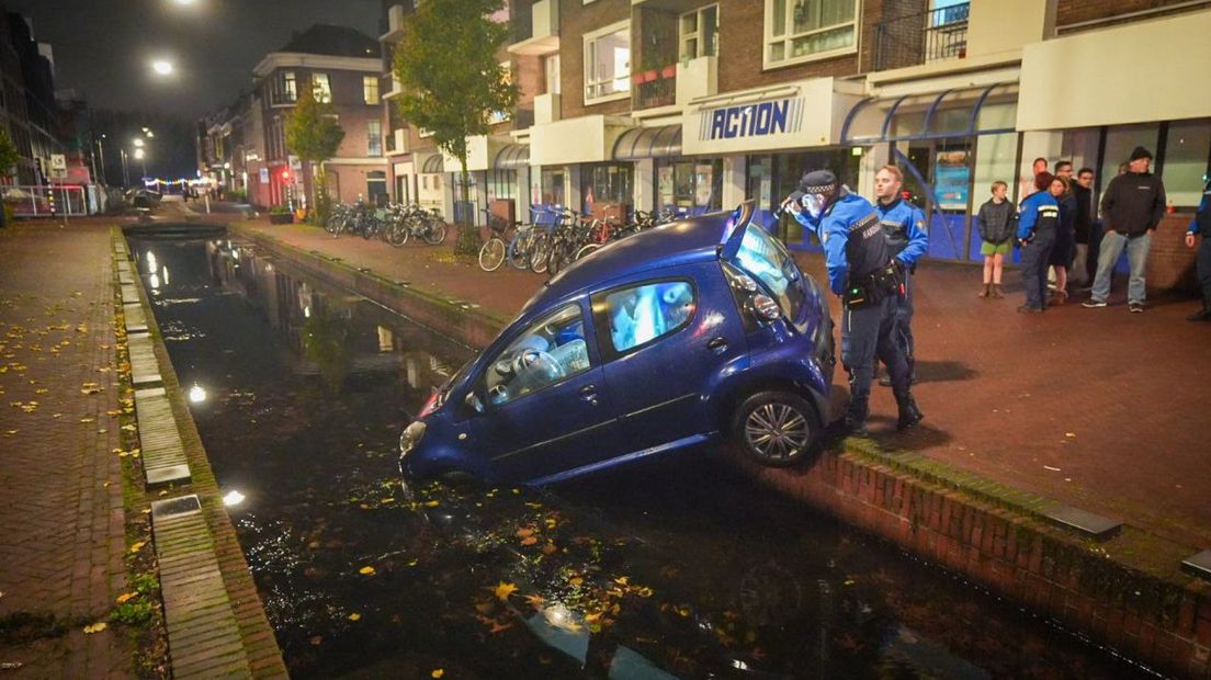 Een auto hangt in het Arnhemse voetgangersgebied van de binnenstad half in de gracht