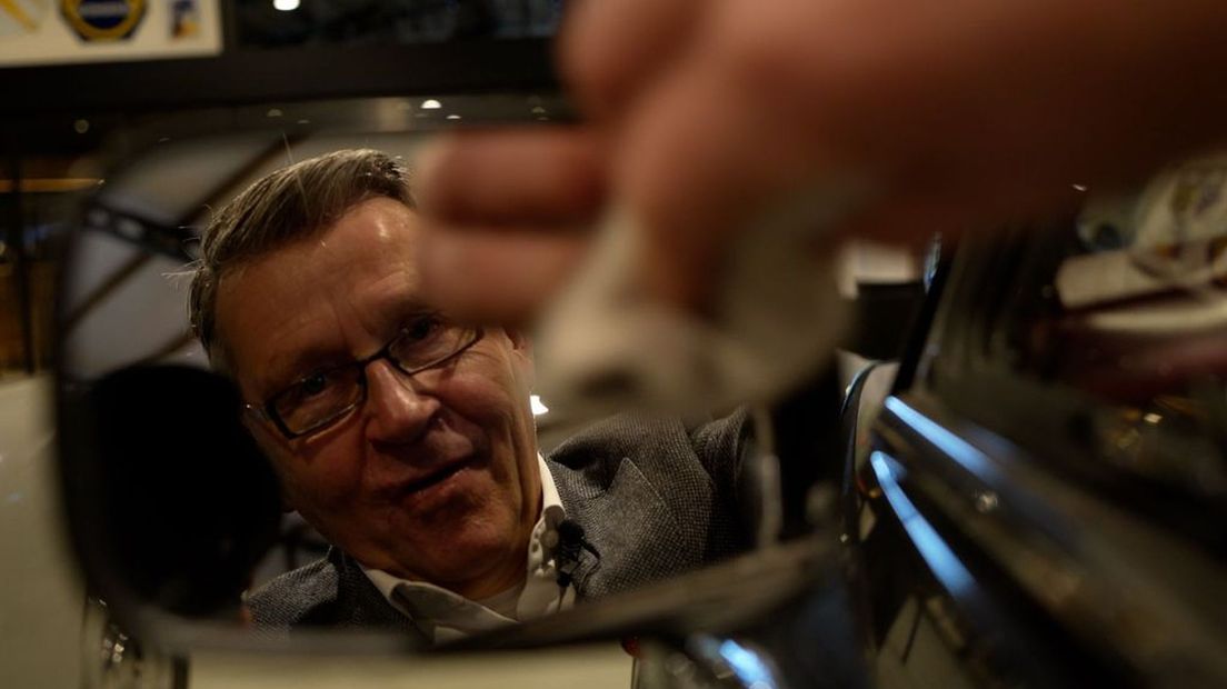 Henk Visscher poetst een autospiegel in zijn nieuwe museum.