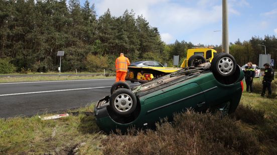 Auto op de kop naast A50 • grote brand in tuin