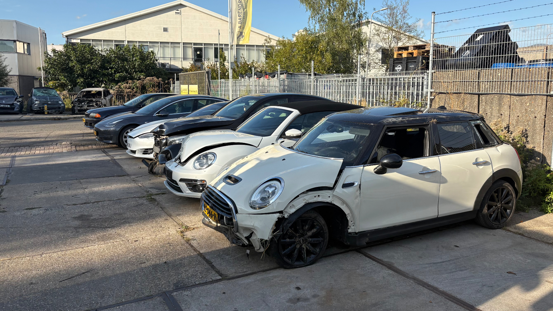 Op het 'kerkhof' staan allerlei auto’s en vrachtwagens; de ene lijkt het van buiten nog perfect te doen en de ander is door de schade amper nog herkenbaar als auto.