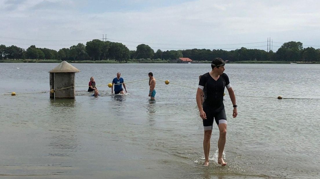 Burgemeester Van Oostrum komt als eerste het water uit.