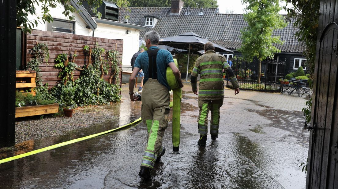 De brandweer is druk met het wegpompen van water bij restaurant De Lage Vuursche.