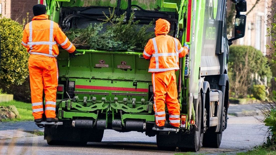 Een vuilniswagen rijdt de kerstbomenroute.