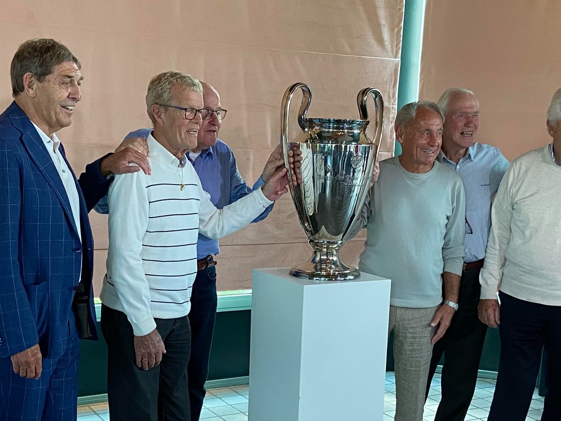 De oud-winnaars van de Europa Cup I van Feyenoord poseren voor de beker