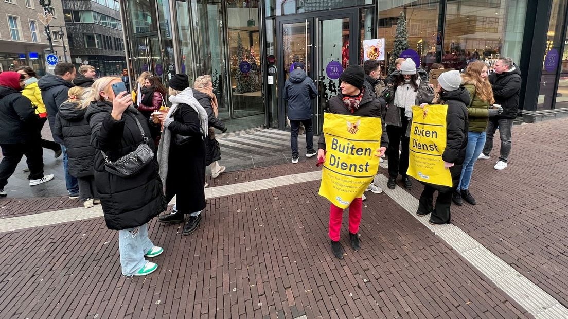 Medewerkers van de Bijenkorf bij de ingang van het warenhuis.
