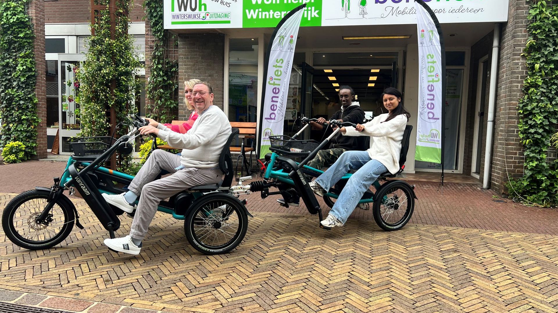 Vrijwilligers van de WUh proberen de nieuwe fiets.