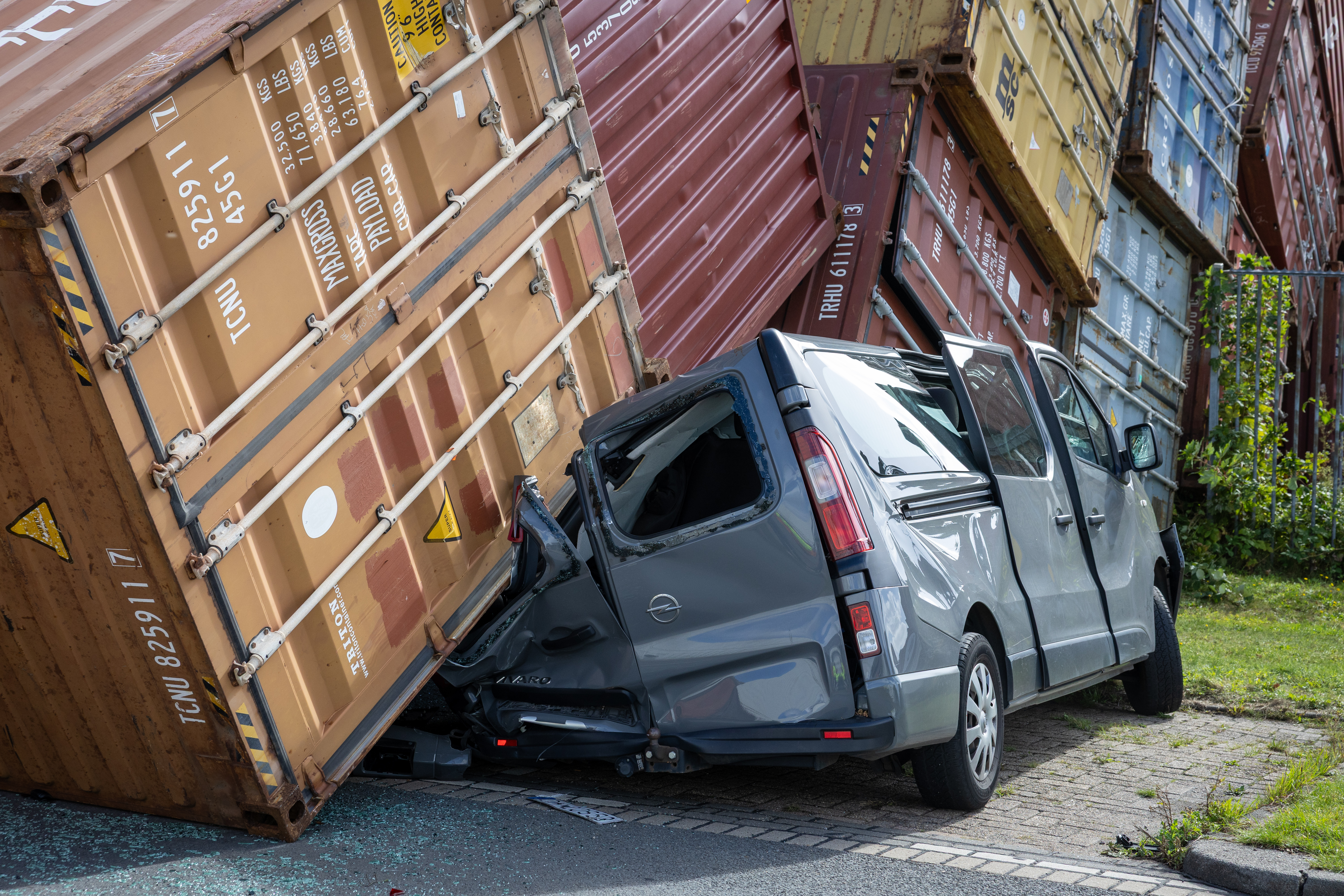 De bestelbus gaat gebukt onder de brute kracht van de containers.