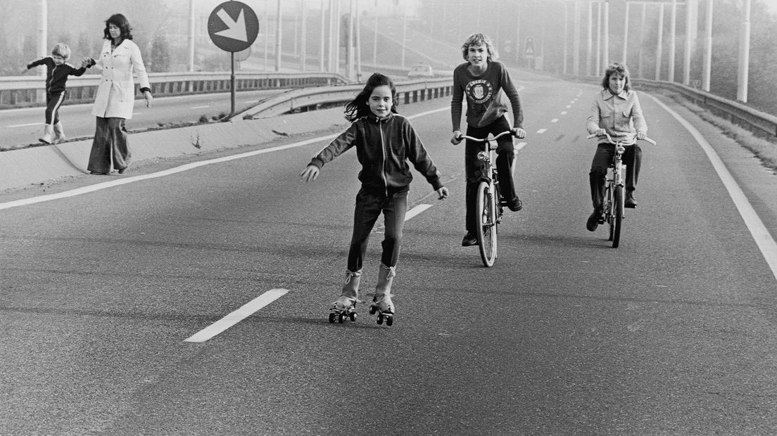 Kinderen rolschaatsen en fietsen op de snelweg tijdens een autoloze zondag in de jaren 70
