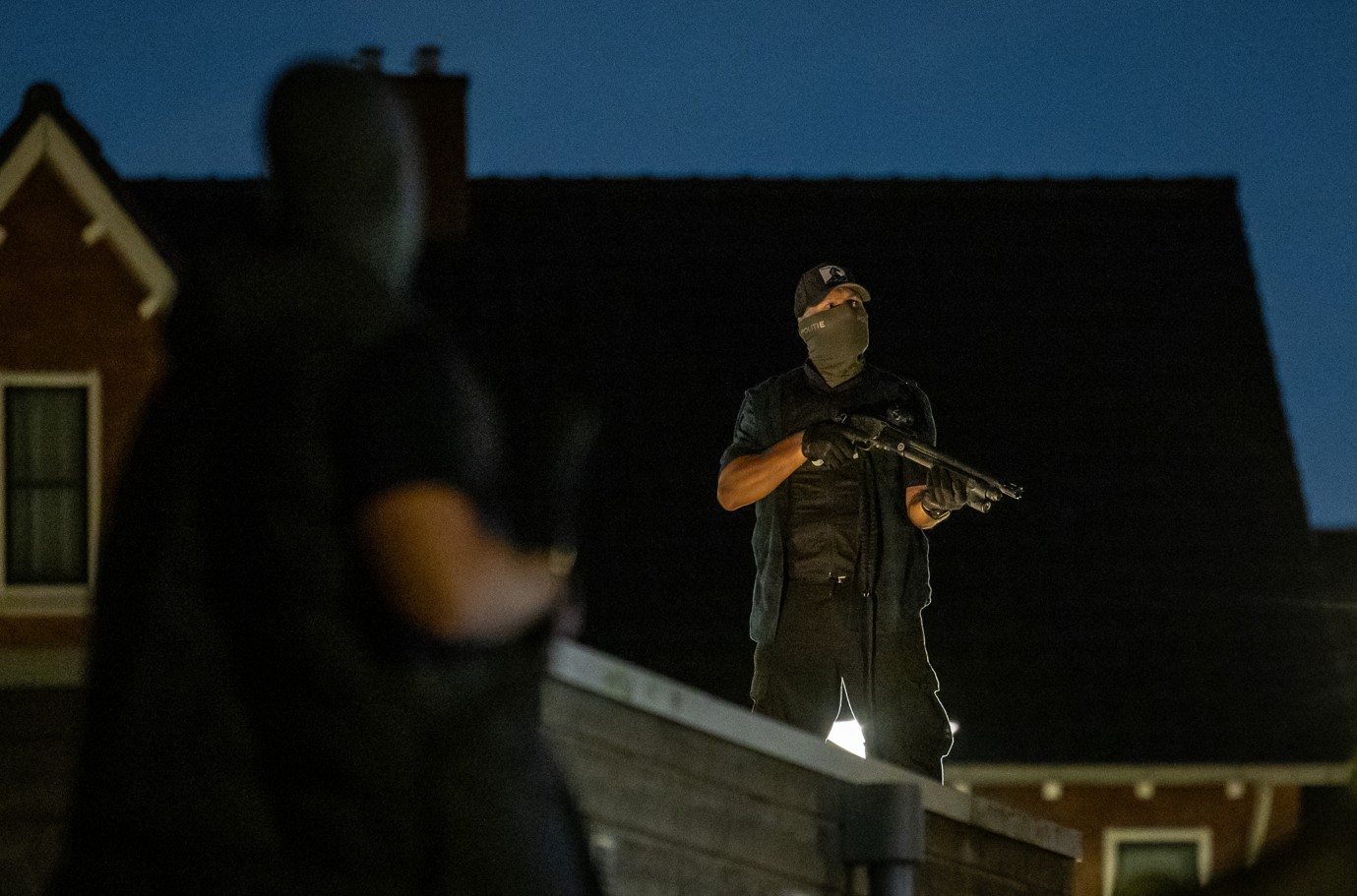 De politie stond zwaarbewapend op daken van schuurtjes