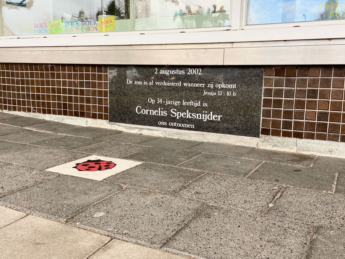 De plaquette ter nagedachtenis aan Cornelis Speksnijder. In de stoep zit een zinloos geweld-steen