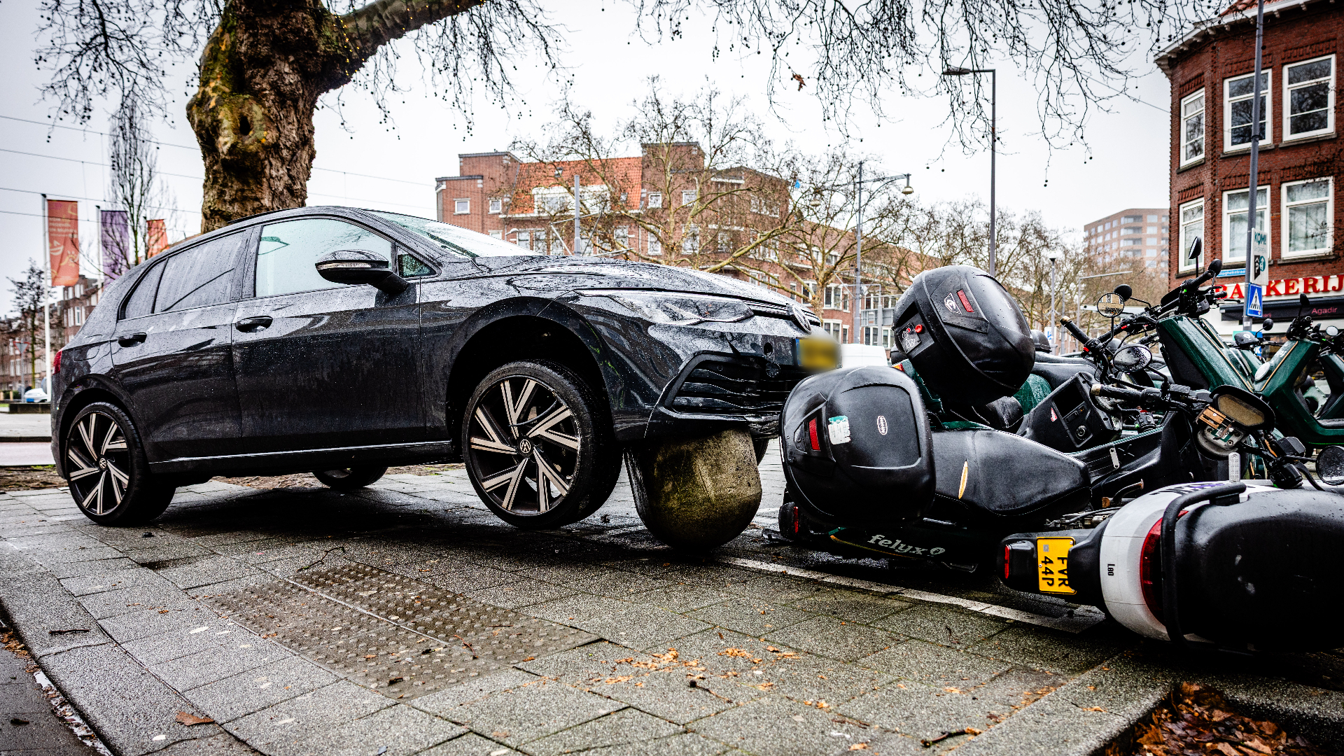 De auto kwam op de biggenrug en tegen de deelscooters tot stilstand.