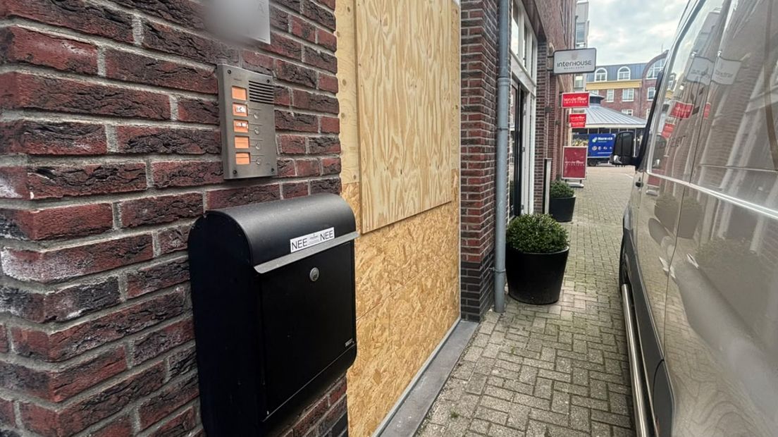 Houten platen op de plek van de verwoeste pui