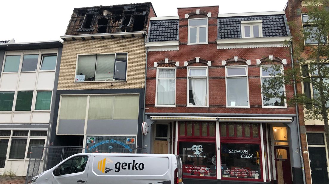 Het uitgebrande pand met rechts daaronder de kapsalon