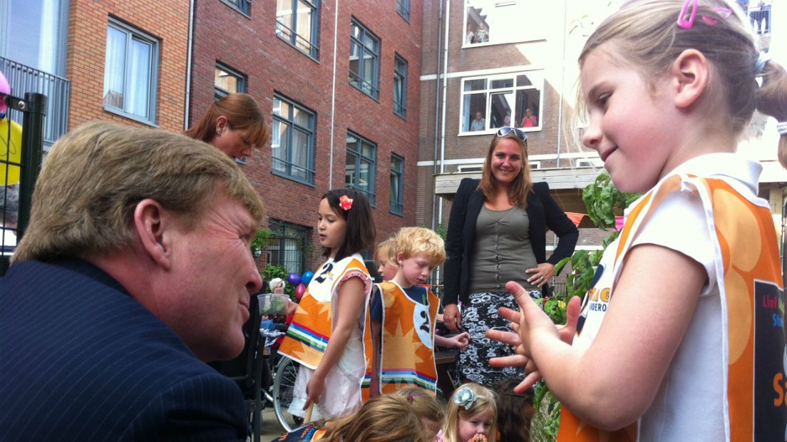 Willem-Alexander spreekt een kind in de Haagse generatietuin
