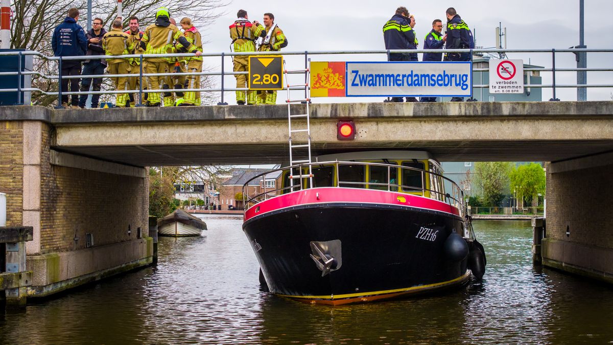 Boot van provincie vaart zich klem onder brug, schip muurvast