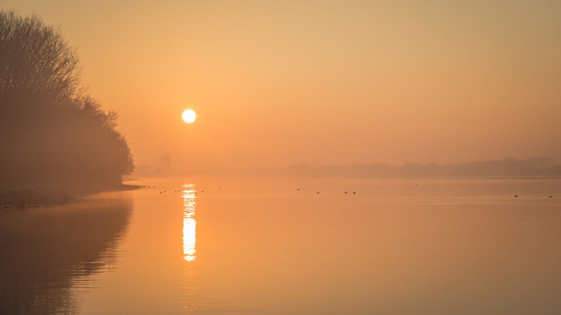 De zon is nog maar net te zien door de mist in Kortgene.