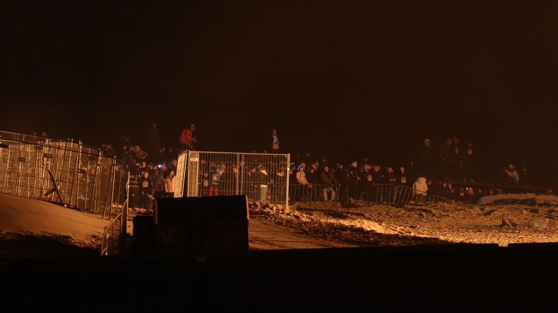 Vanaf het strand kijken mensen naar het vuur