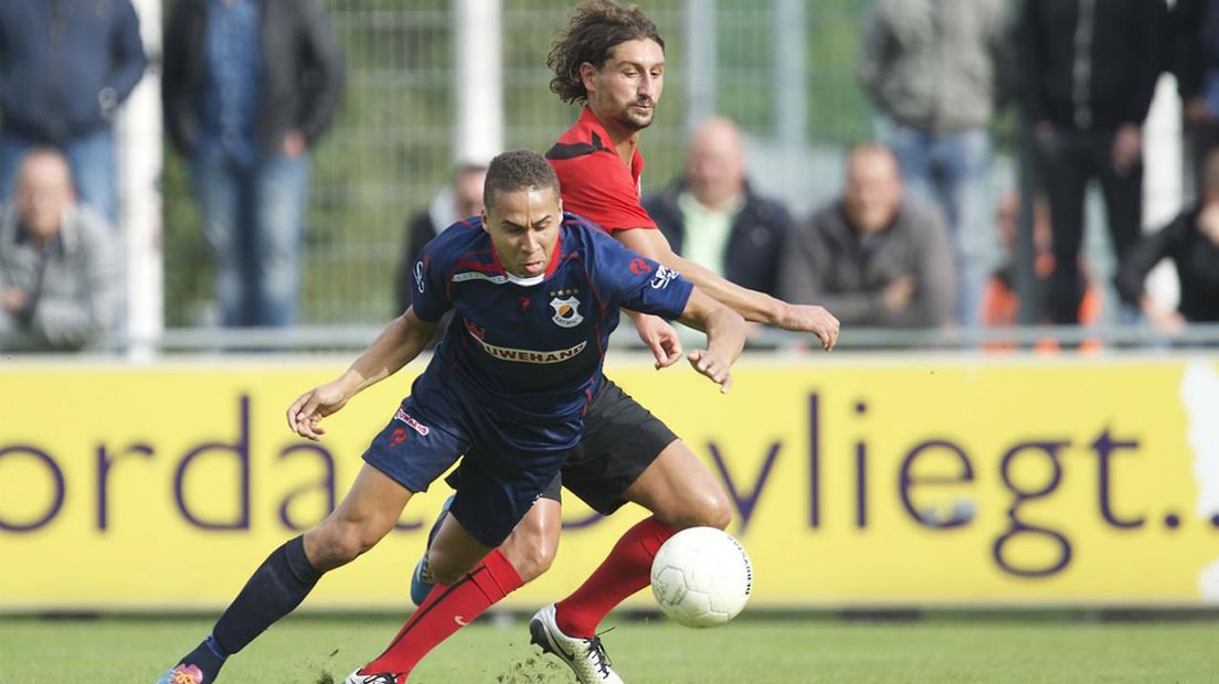Katwijk-speler Marciano Mengerink in duel met Magid Jansen van AFC