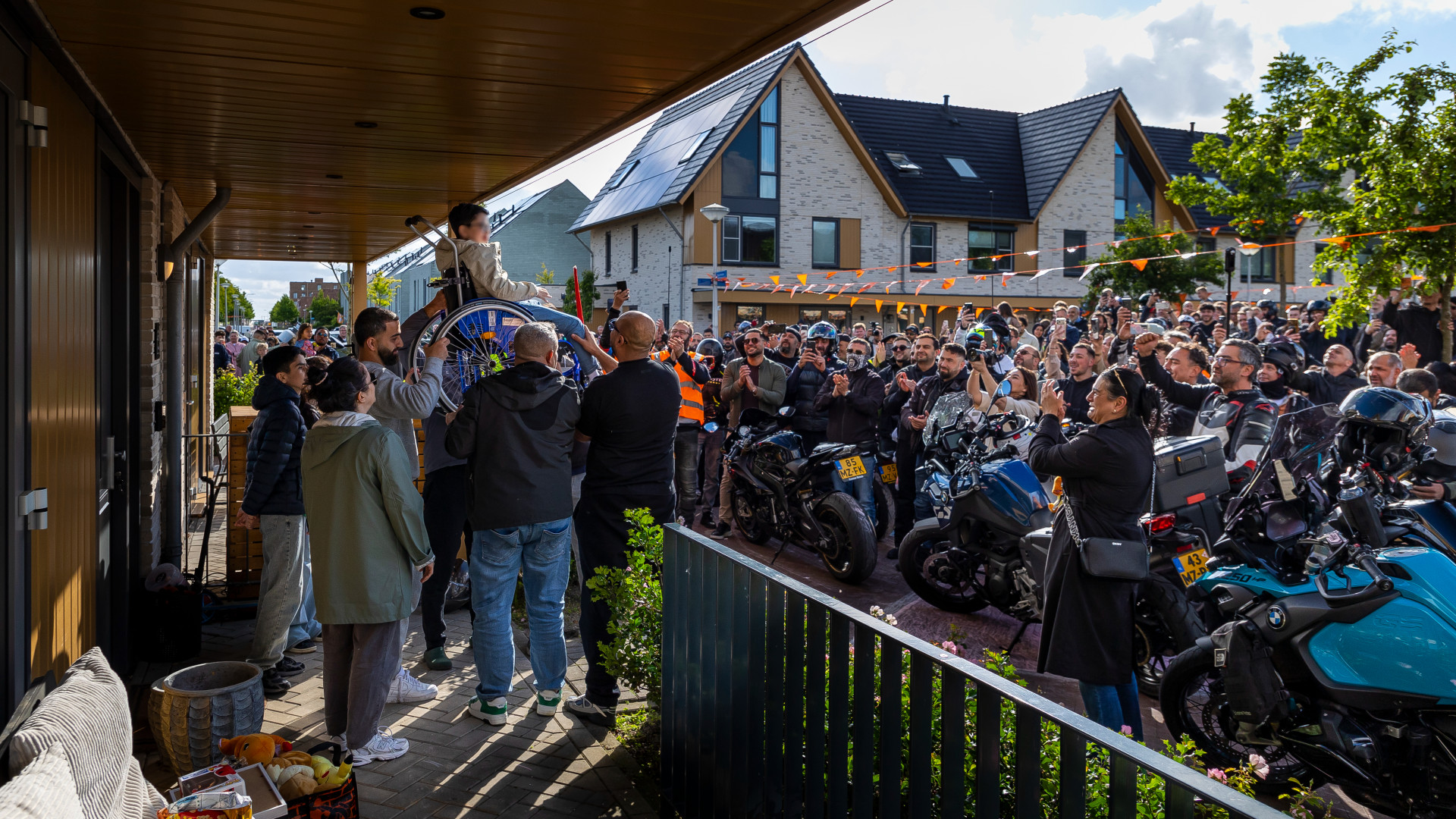 Voor een grote menigte wordt Miraç in zijn rolstoel opgetild