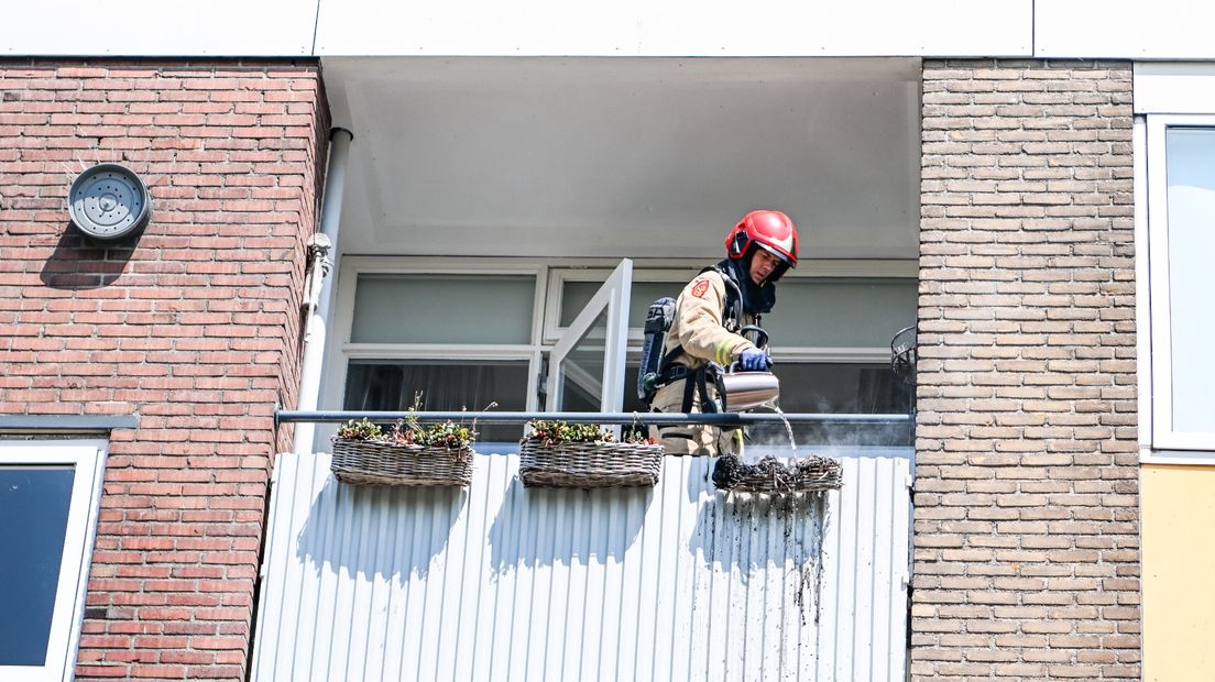 Een brandweerman blust het brandje in Hoogezand met een waterkoker