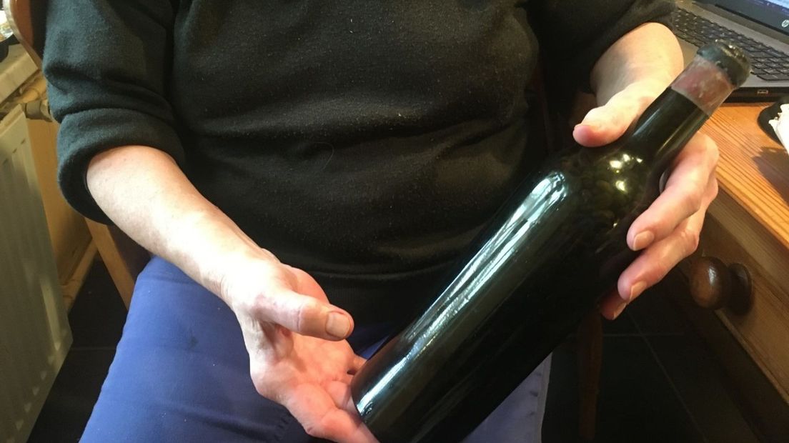 Carolina Verhoeven toont wijnfles met koffiebonen (Rechten: RTV Drenthe / Sophie Timmer)