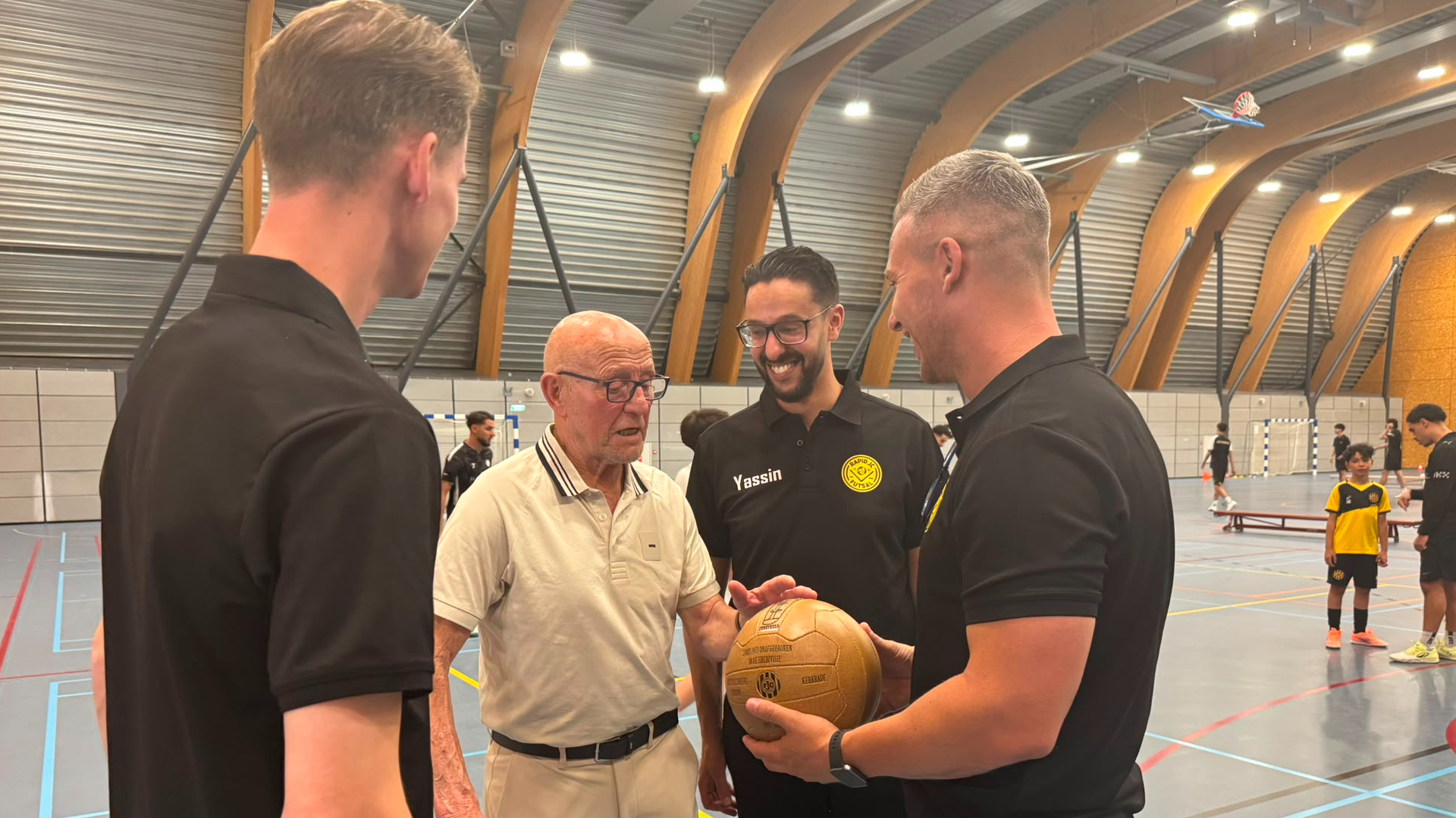 Oud-Rapid JC'er Pierre Kusters overhandigt symbolisch de bal