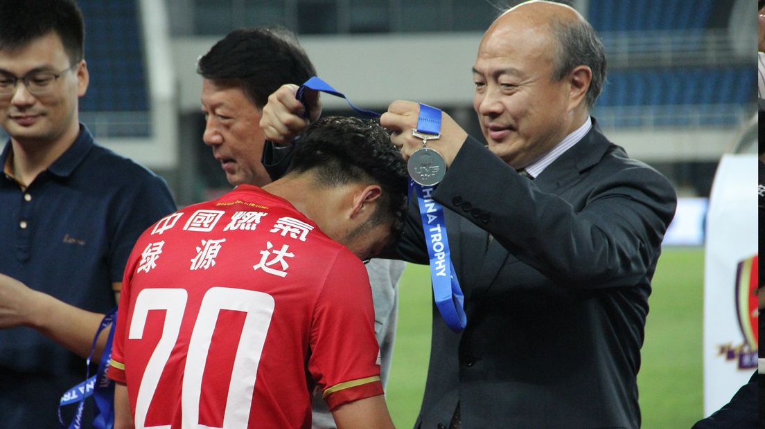Wang Hui geeft een medaille aan een Chinese speler