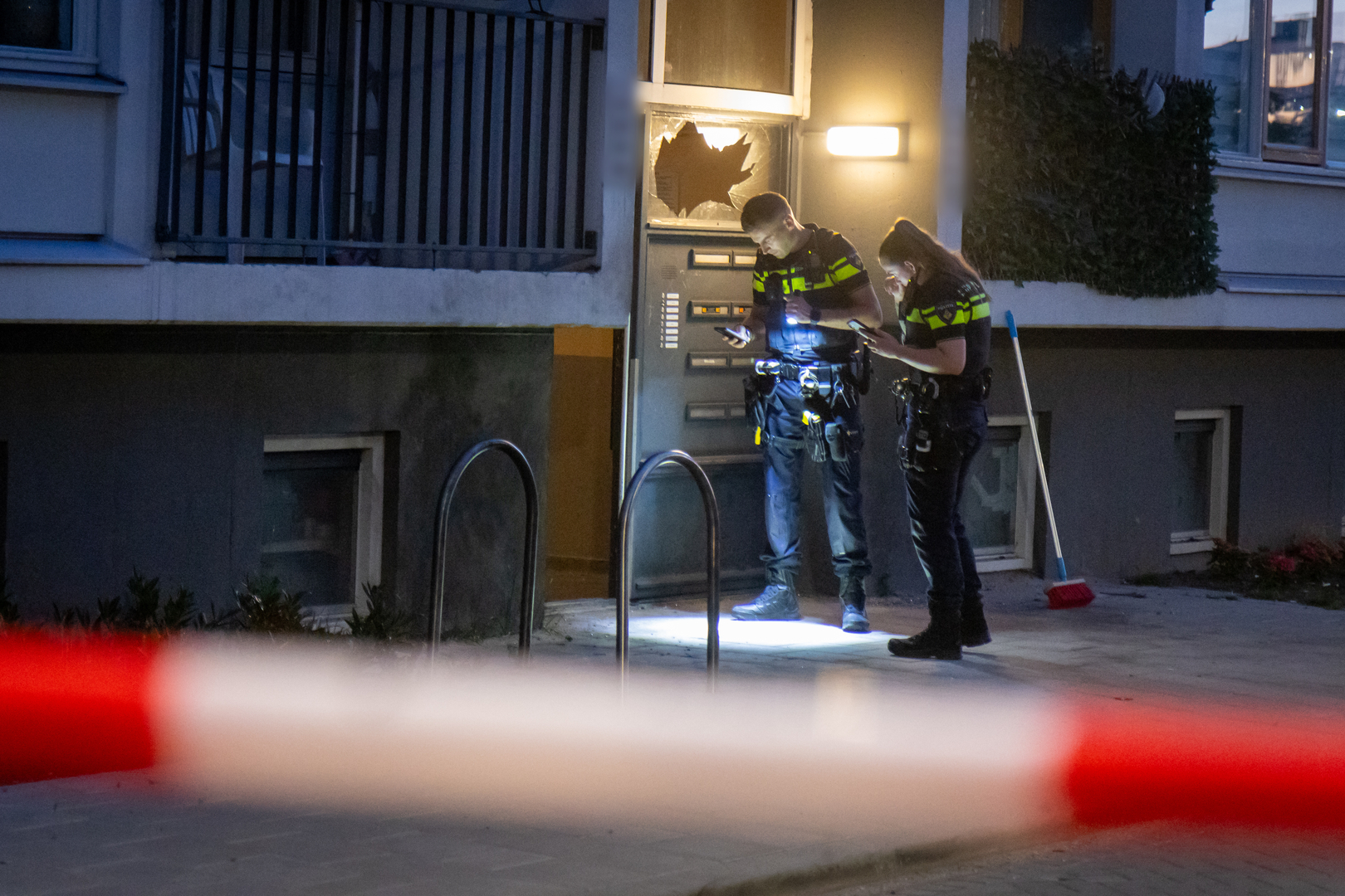 De politie doet onderzoek bij de portiekflat.