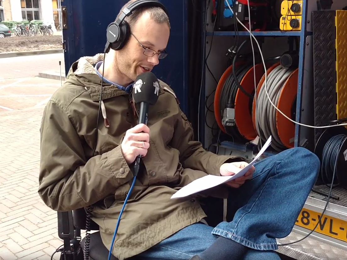 Nieuwslezer Aries van Meeteren leest buiten het handgeschreven nieuws voor via Radio West