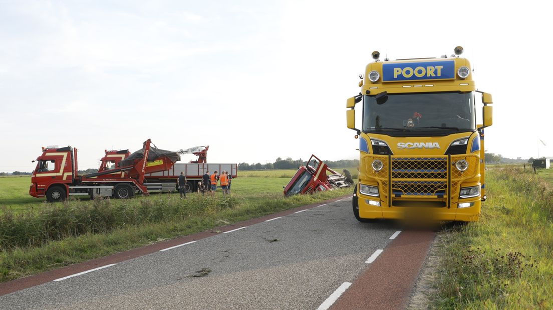 De vrachtwagen ligt zijdelings in de sloot