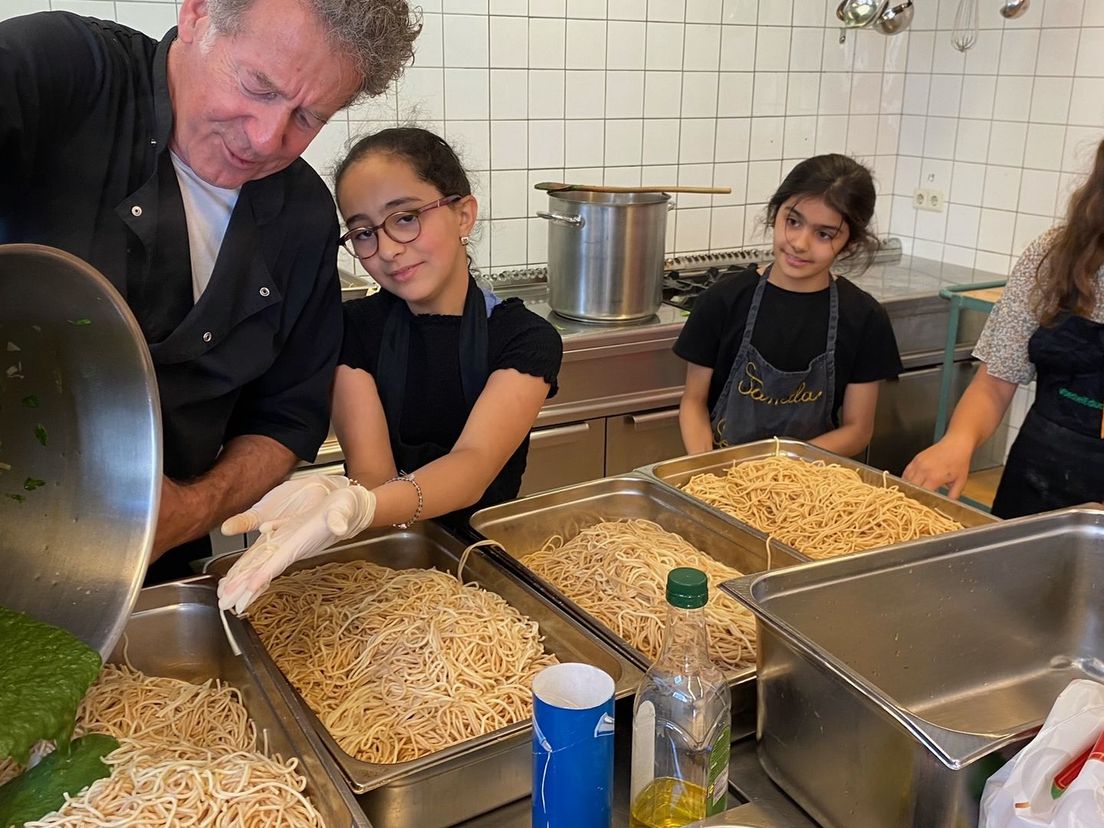 Kok Ralph voegt de spinaziesaus toe voor de groene spaghetti