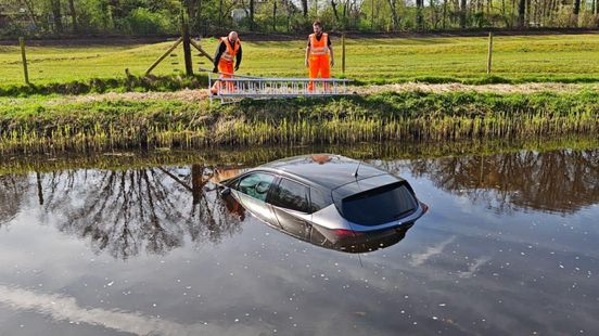 Auto rolt water in • scooterrijder in sloot