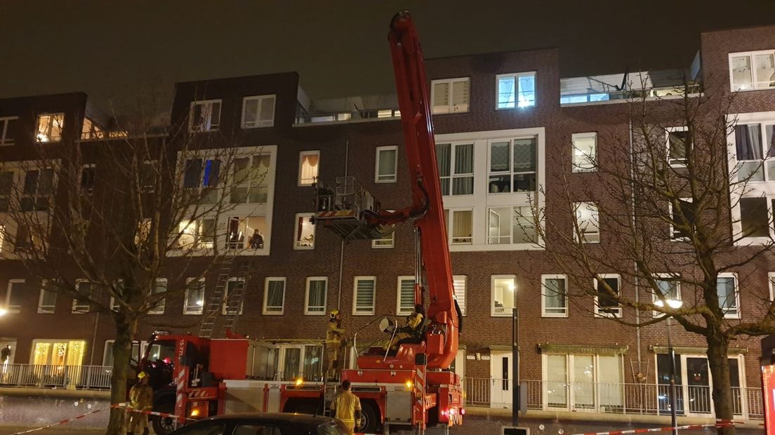 De brandweer evacueert bewoners van het flatgebouw