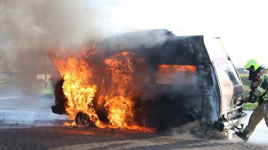 Camper gaat volledig in vlammen op, zwarte rook vanaf snelweg zichtbaar