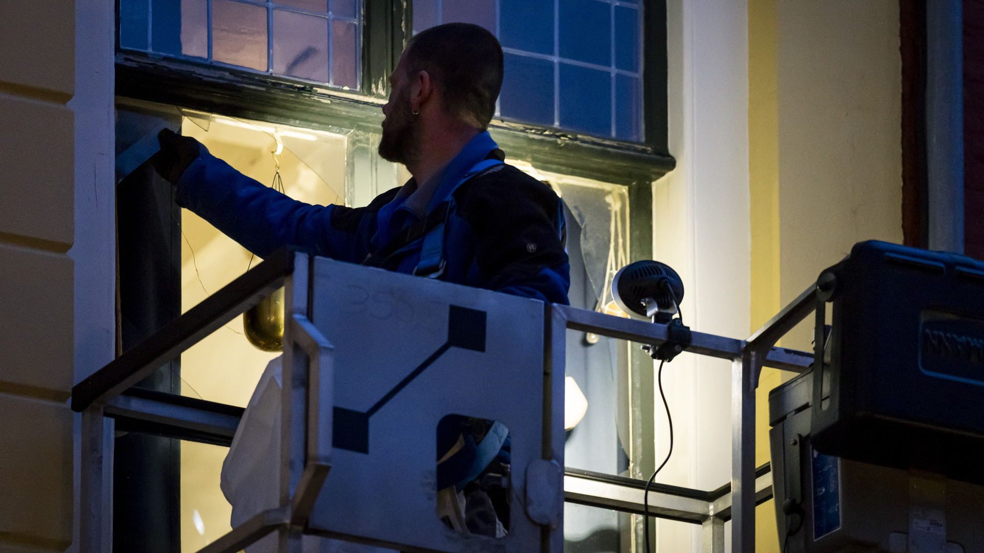 Werkzaamheden na explosies in volle gang: werklui druk met herstellen van ruiten