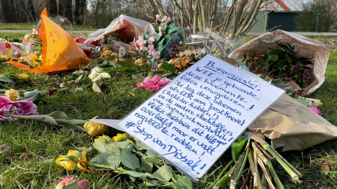 Bloemen met een activistische tekst op een graf op de begraafplaats in Bodegraven.