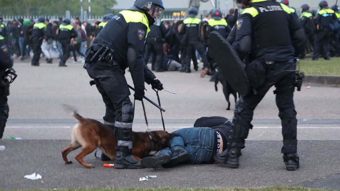 De politie zet honden in bij de ongeregeldheden