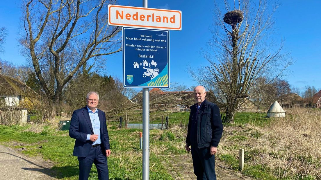 Wethouder Marcel Scheringa en bewoner Jan Bezemer onthullen samen het verkeersbord bij Nederland