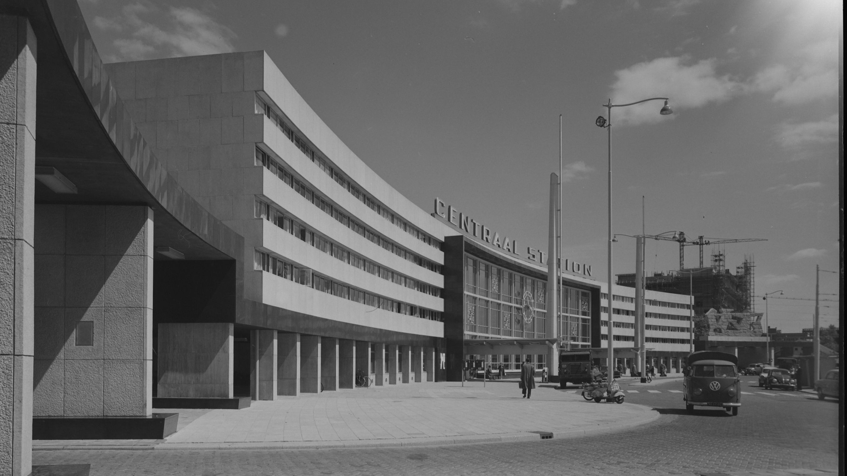 De voorgevel van Rotterdam Centraal aan het Stationsplein in 1957. In de achtergrond wordt het Postkantoor aan het Delftseplein gebouwd.