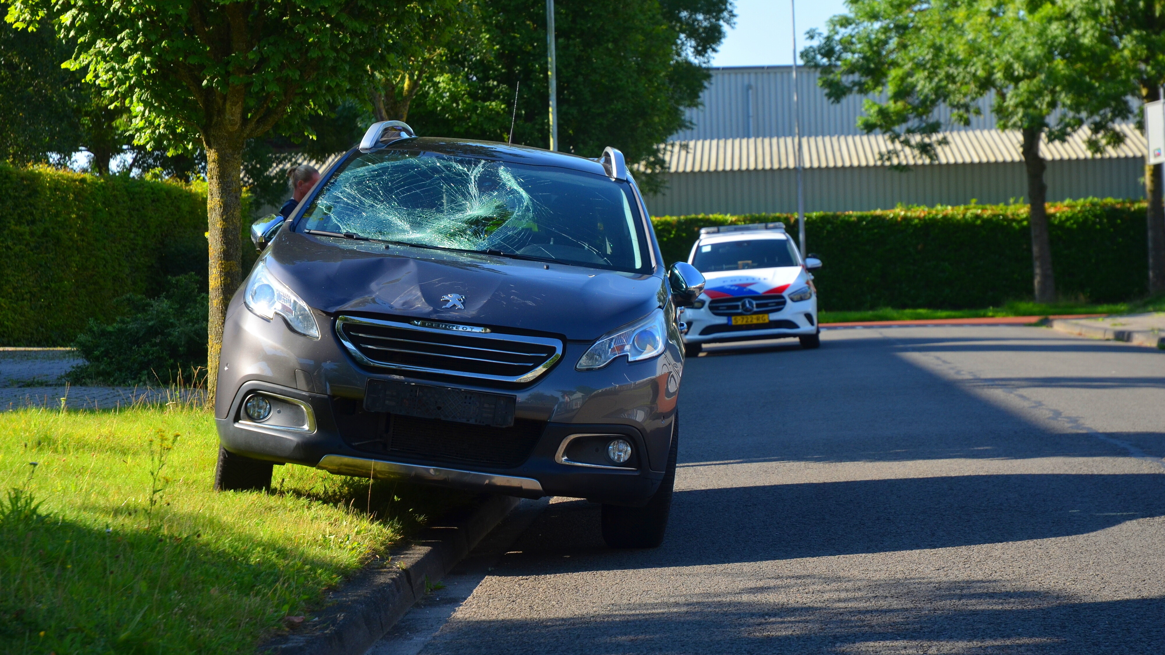 De voorruit van de auto is beschadigd geraakt bij de botsing