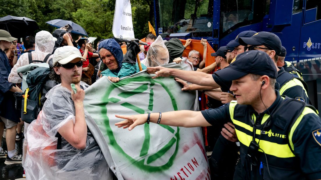 Demonstranten staan voor de waterwerper van de politie