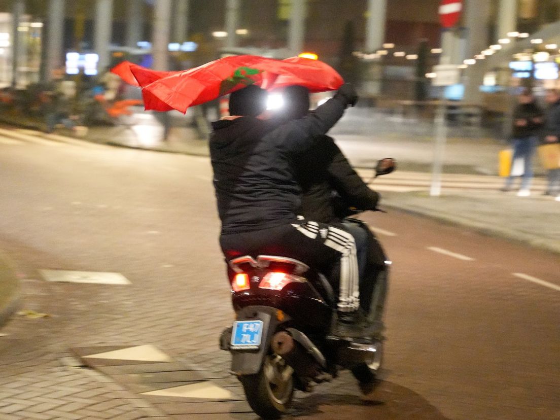Met wapperende vlaggen rijden blije supporters door de straten van Rotterdam